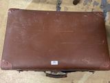 a brown piece of luggage sitting on the floor