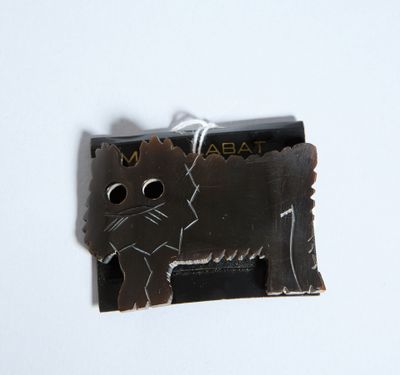 un chat noir assis sur une feuille de papier