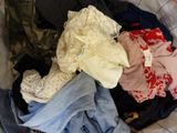 un tas de vêtements dans une valise posée sur un lit