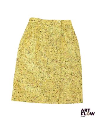 La jupe est jaune et présente un petit motif.