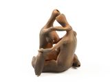 a sculpture of a man and a woman sitting on the ground