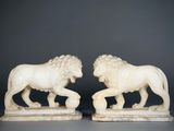 paire de lions sculptés en ivoire sur socles en marbre