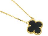 a gold necklace with a black flower on it