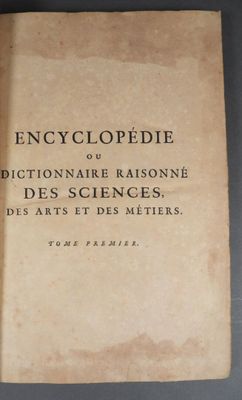 un vieux livre posé sur une table couverte d'écritures