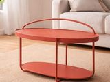 une table basse rouge posée sur un tapis dans un salon