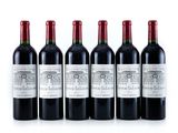 six bouteilles de vin rouge alignées sur une surface blanche