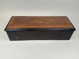 a small wooden box with a black and brown design on the lid