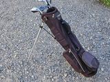 un sac de clubs de golf posé par terre près d'un mur