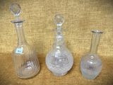 trois vases en verre posés sur une table l'un à côté de l'autre