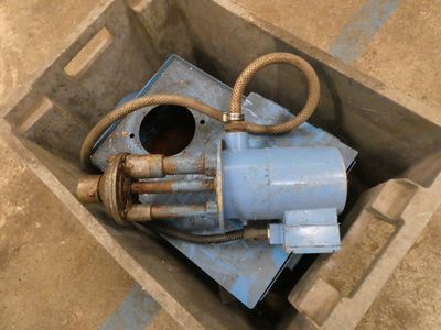 a blue water pump sitting in a box on the ground