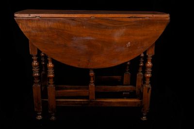 a small table with a wooden top on a black background