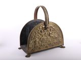 un sac à main doré et noir posé sur un support