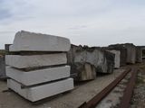 a pile of concrete blocks on the ground next to a train track