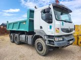 a green dump truck that is parked in the dirt
