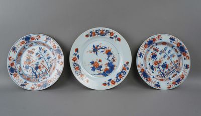 trois assiettes bleues et blanches ornées de fleurs orange