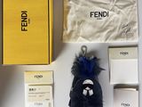 a box with a keychain, a bag with a bag tag, and other items on a table