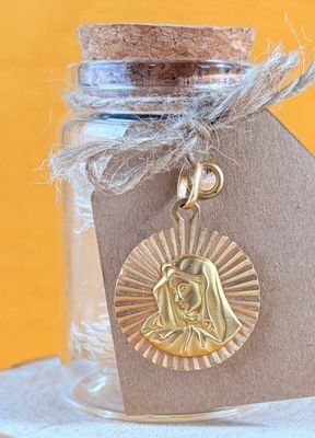 a small glass jar with a gold medal in it