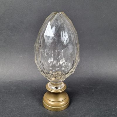 an image of a glass and brass vase on a black background
