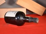 a bottle of wine sitting on a table next to a block of wood