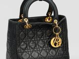 un petit sac noir avec des finitions dorées sur la poignée