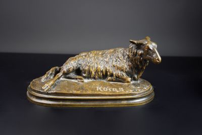 statue en bronze représentant un mouton couché sur une surface noire