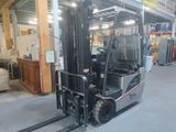 a fork lift truck in a warehouse with pallets in the background