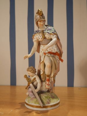 une figurine représentant une femme tenant une épée, posée sur une table
