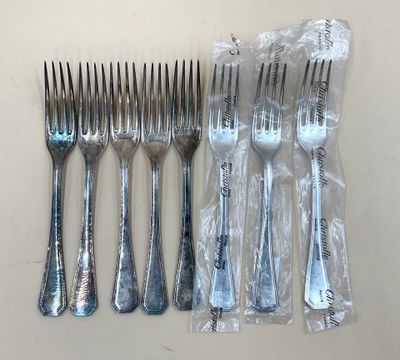 six fourchettes et un couteau dans un sac posé sur une table