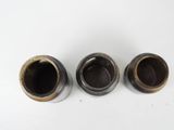 three black and gold vases sitting next to each other on a white surface