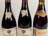 trois bouteilles de vin sont alignées sur une surface blanche