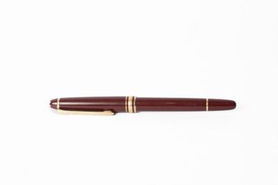 un gros plan d'un stylo posé sur une surface blanche