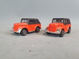 two toy cars sitting next to each other on a white surface