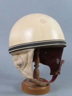 une image représentant un casque posé sur un socle en bois, sur fond gris