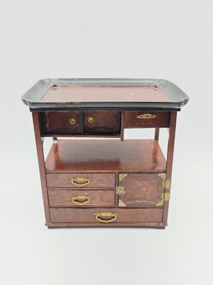 une image représentant une petite table en bois avec deux tiroirs et un plateau posé dessus