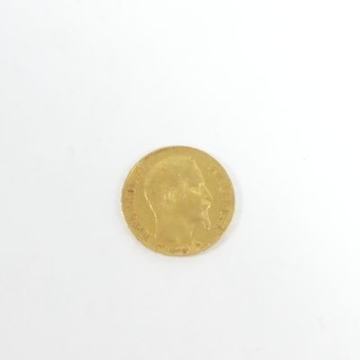 gros plan d'une pièce d'or sur une surface blanche