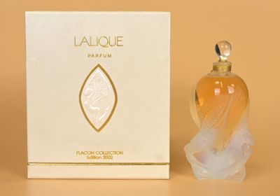 an image of a bottle of perfume sitting next to a box