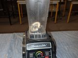 a blender sitting on a table next to a frying pan