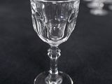 a glass of wine sitting on a table with other wine glasses in the background