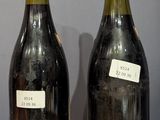 two bottles of wine sitting on a table next to each other