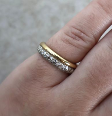 la main d'une femme tenant une bague en or et en argent