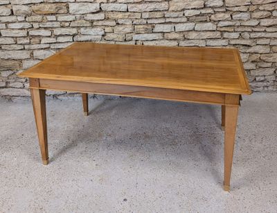 a wooden table that is sitting in front of a stone wall
