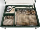 a green case with silverware in it on a white surface