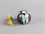 une boule en marbre noir et blanc sur laquelle est représentée une feuille