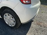 a small white car parked on the side of the road