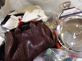 a brown purse sitting on top of a pile of items