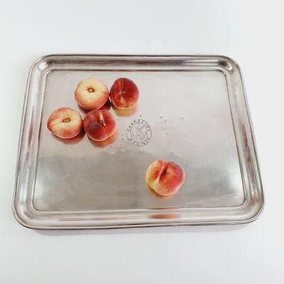 a metal tray with peaches on it on a white table