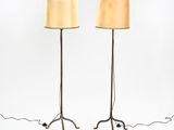 a pair of floor lamps with lampshads on each of them
