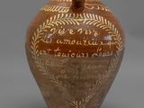 une image représentant un vase marron sur lequel figure une inscription