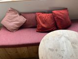 a couch with pillows and a table in the corner