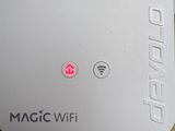 a white wifi router on a table next to a mouse